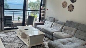 A modern living room with a grey sofa, a white coffee table, and a patterned rug.