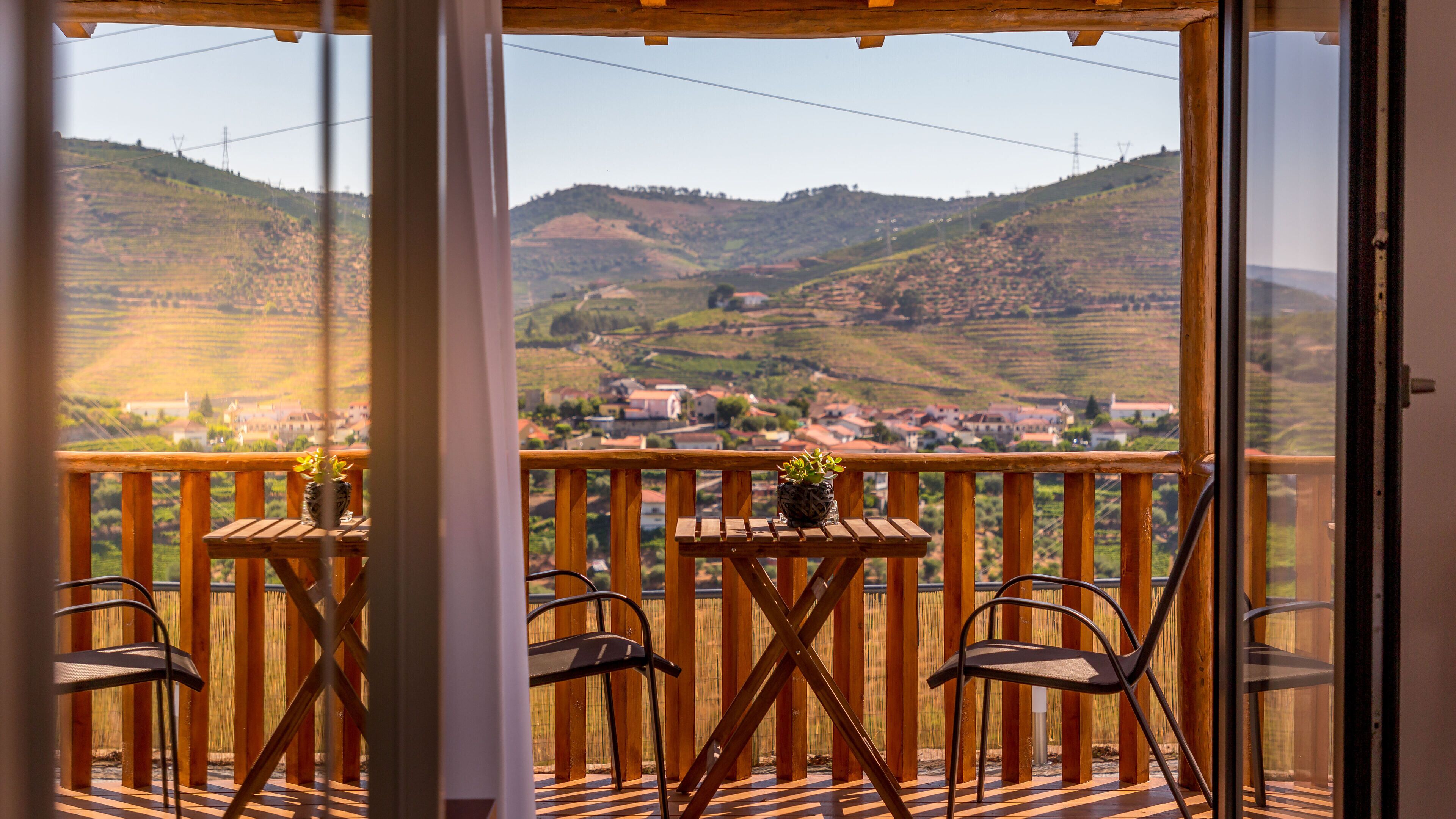 Ein Balkon mit Holzbalkonen, einem Tisch mit Stühlen und einem Blumentopf.