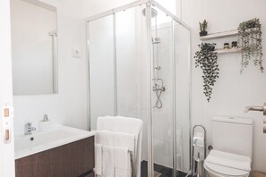 A modern bathroom with a glass shower enclosure, a white sink, and a toilet. - Quinta da Portela Douro (Armamar)