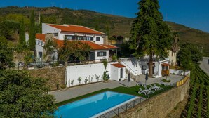 A large villa with a swimming pool, multiple balconies, and a vineyard in the background. - Quinta da Portela Douro (Armamar)