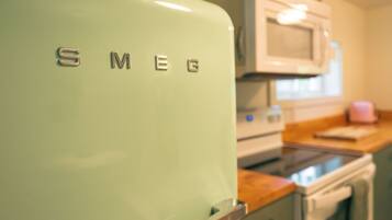 Una cocina con un refrigerador verde claro, un microondas y una estufa.