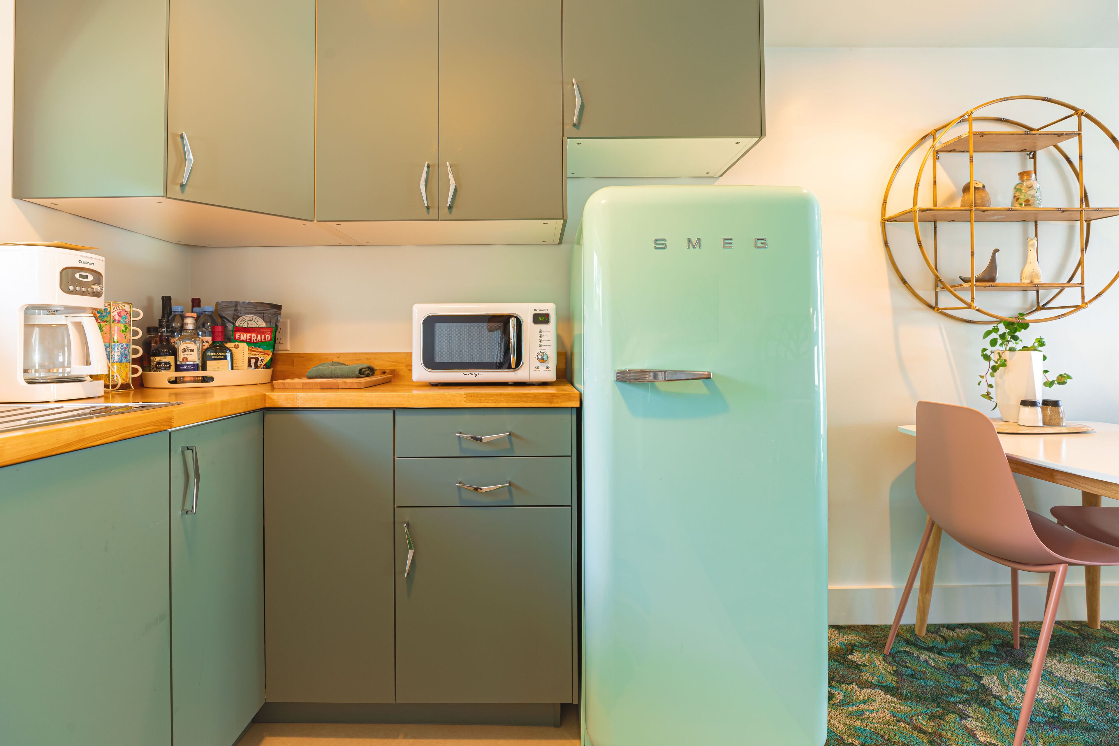 A kitchenette with a vintage-style fridge, a coffee maker, and a microwave.