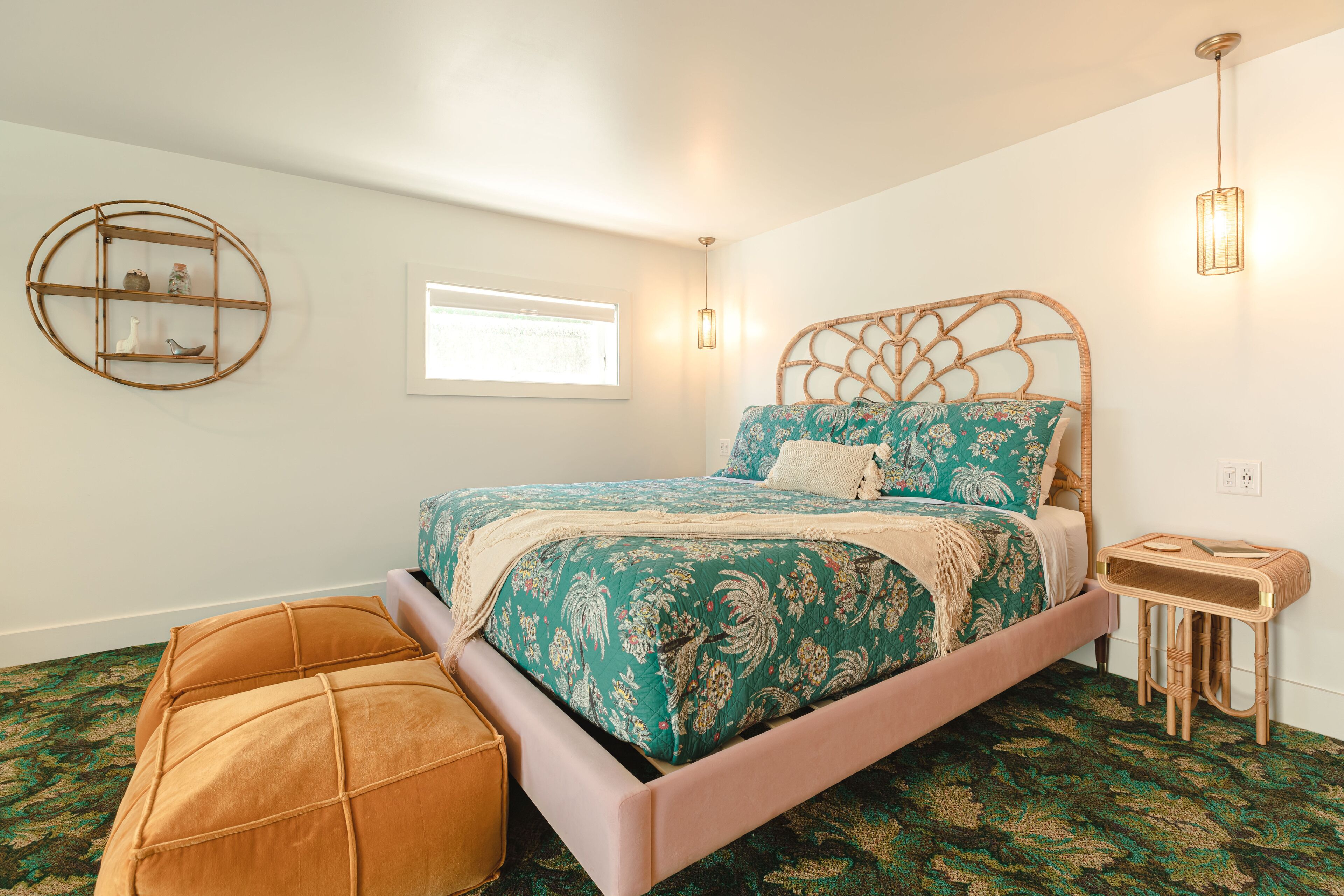 A bedroom with a bed, a round wall shelf, a window, and a bedside table.