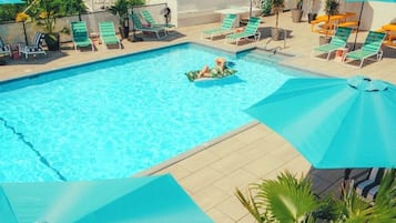 Alberca al aire libre por temporada y sombrillas en la alberca