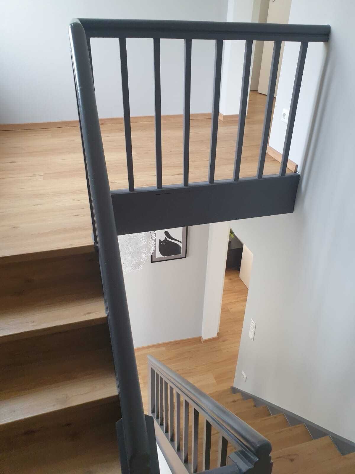 A staircase with wooden steps and a black metal railing.