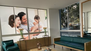 A modern living room with a large window, a green sofa, a wooden coffee table, and a teal armchair. - Executive apartment (Cali)