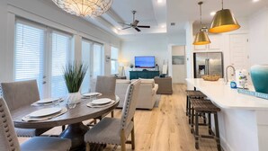 Cocina moderna con comedor, que incluye una mesa redonda de madera, sillas y un ventilador de techo.