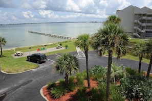 A parking lot with a view of a body of water and a pier.