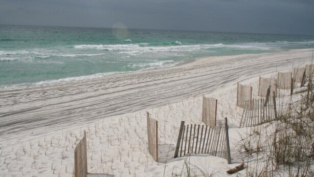 A beach with a wooden fence and a sandy path leading to the water. - Quaint Beach Condo with Bay Views, Covered Parking, Pool, Bay Beach -Baywatch C4 (Pensacola Beach)