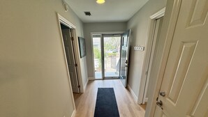 A hallway with a black carpet, wooden flooring, and a door on the right. - Completely Updated Luxury Villa in Sea Pines - Beautiful Lagoon View. (Hilton Head Island)