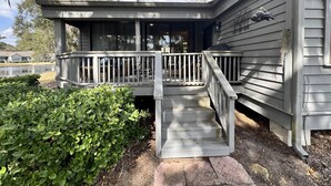 A house with a covered porch and a staircase leading to the entrance. - Completely Updated Luxury Villa in Sea Pines - Beautiful Lagoon View. (Hilton Head Island)