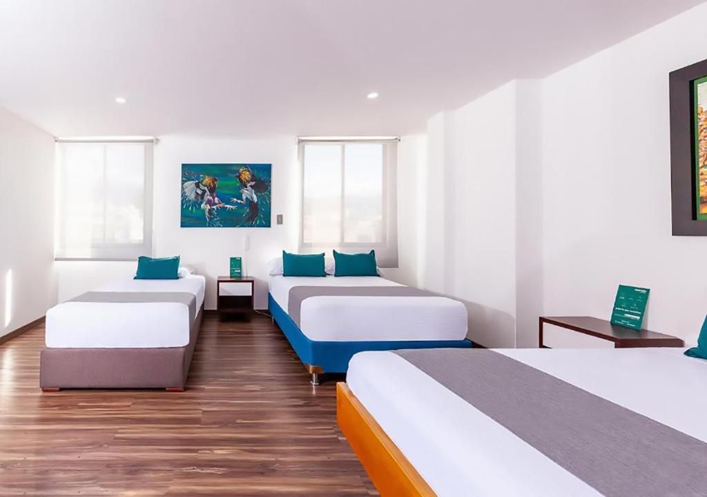 A hotel room with two single beds, a large window, and a painting on the wall.