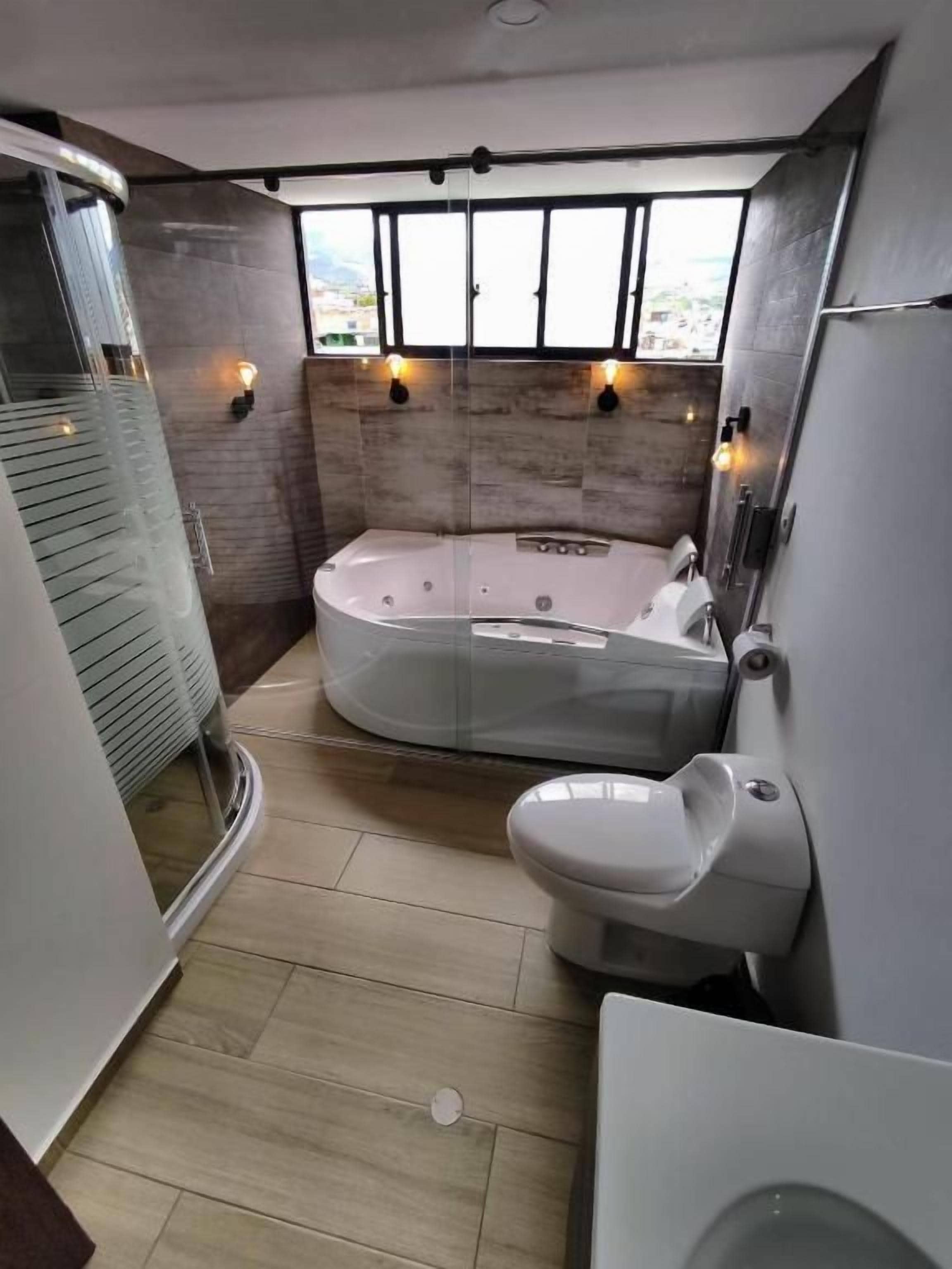 Un baño pequeño con bañera, inodoro y cabina de ducha.