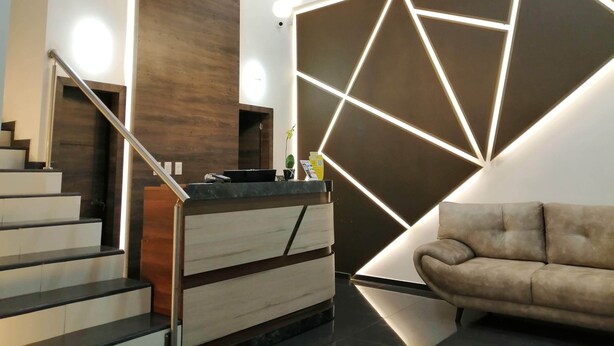 A modern interior with a staircase, a geometric wall design, and a sofa. - Hotel Basan Plaza (San Juan de Pasto)
