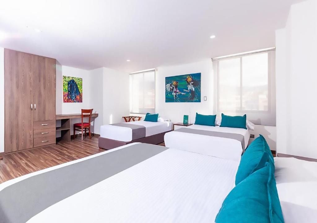 Une chambre d’hôtel avec un grand lit, deux petits lits, un bureau et une chaise. Les murs sont ornés de tableaux et il y a une fenêtre avec vue.