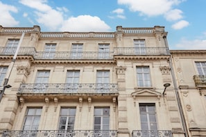 A multi-story building with ornate balconies and classical architectural details.