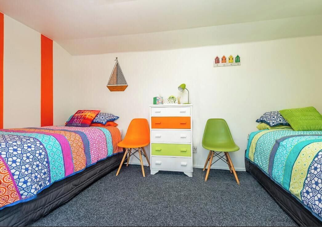 Ein Schlafzimmer mit zwei Betten, einem Schminktisch und zwei Stühlen.