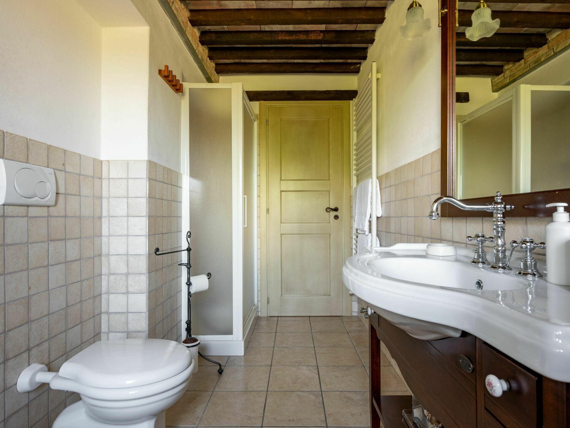 A bathroom with a toilet, sink, and shower.
