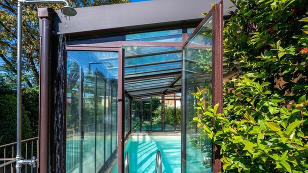 A glass-enclosed outdoor pool area with a metal railing and a clear view of the surrounding greenery. - Wonderful  villa for 8 guests with private pool, A/C, WIFI, hot tub, TV and terrace (Narzole)