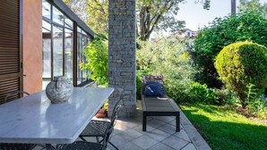 An outdoor patio with a table and chairs, a stone pillar, and a wooden bench. - Wonderful  villa for 8 guests with private pool, A/C, WIFI, hot tub, TV and terrace (Narzole)