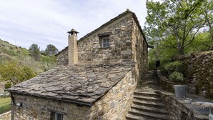 Il s’agit d’un bâtiment en pierre, doté d’un toit en pente et d’une cheminée. Des marches mènent à l’entrée du bâtiment.