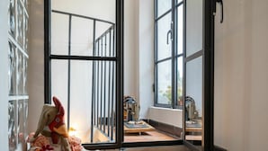 A room with a large window, a plush toy, and a sewing machine. - Lovely apartment for 4 people with terrace (Dolcedo)