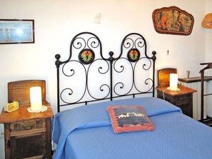 A bedroom with a bed, a nightstand, a wooden dresser, a lamp, and a painting on the wall. - Wonderful private villa for 7 guests with WIFI, TV, terrace, pets allowed and panoramic view (Imperia)