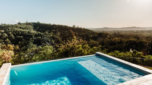 Une piscine rectangulaire à l’eau d’un bleu limpide, entourée d’une terrasse carrelée.