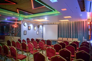 A conference room with rows of red chairs, a whiteboard, and a clock on the wall. - Hotel Victory Abashik Cumilla (Comilla)