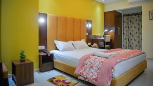 A modern bedroom with a large bed, bedside tables, a nightstand, a small plant, and a patterned rug. - Hotel Victory Abashik Cumilla (Comilla)