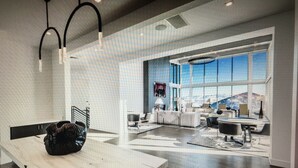 A spacious, modern interior with a large dining area, a kitchen, and a seating area with a view of the outdoors.
