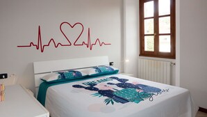 Un dormitorio con cama, ventana y decoración en la pared.