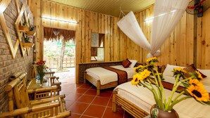 A wooden-themed room with two beds, a dining table, and a hanging mosquito net. - Hoa Lu Eco Homestay - Hostel (Tay Hoa Lu)