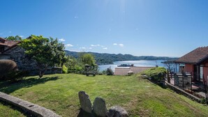 A view of a lakeside property with stone buildings, a grassy lawn, and a clear sky. - Beautiful private villa for 6 guests with WIFI, TV, patio and pets allowed (Pella)