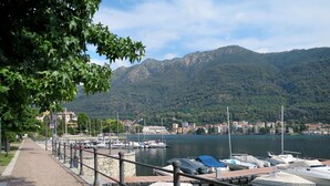 A marina with boats docked, a stone pathway, and a mountainous backdrop. - Beautiful private villa for 6 guests with WIFI, TV, patio and pets allowed (Pella)