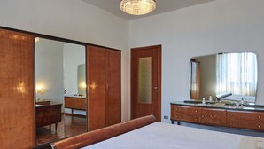Une chambre à coucher avec un grand lit, une armoire en bois et une commode avec un miroir.