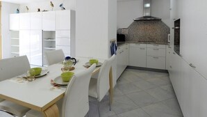 Una cocina moderna con armarios blancos, encimera de granito y horno empotrado.