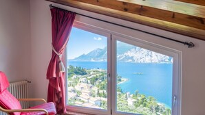 Una habitación con un ventanal grande que ofrece vistas a un pueblo costero y al mar.