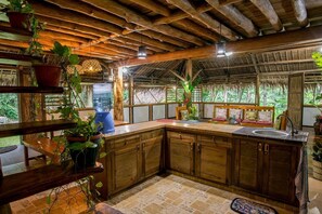 Eine rustikale Küche mit Holzausbau, einem großen Wasserspender und verschiedenen topfgepflanzten Pflanzen.