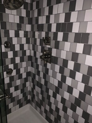 Regadera, tina de hidromasaje, toallas, papel de baño