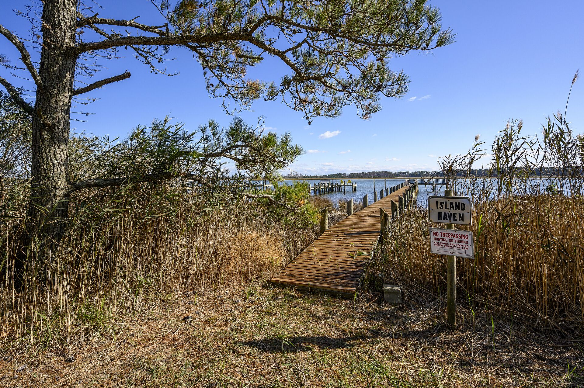 A wooden pier leading to a dock on a clear day.