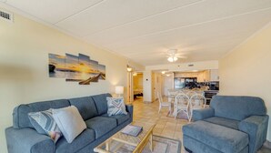Un salon comprenant deux canapés, une table basse et un coin repas avec des chaises.