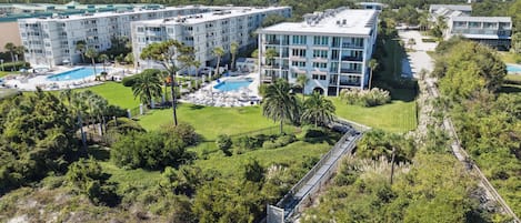 A resort with multiple buildings, a swimming pool, and a beach area.