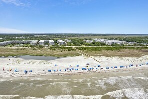 Une station balnéaire dotée de villas en bord de mer, d’une plage de sable et offrant une vue dégagée sur l’océan.