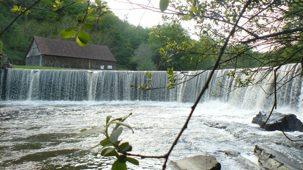 A waterfall with a wooden structure in the background. - Country house for 4 people (Savignac-Lédrier)