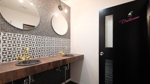 A bathroom with two sinks, a mirror, and a door labeled "Bathroom". - Apartment with terrace (大阪市)