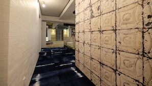 A hallway with a patterned wall and a blue carpet. - Apartment with terrace (大阪市)