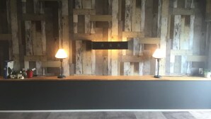 A reception desk with a rustic wooden wall backdrop, two lamps, and a sign with stars. - Apartment with terrace (大阪市)