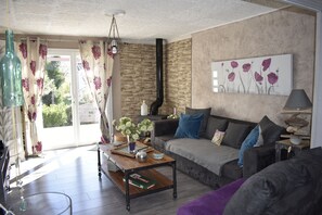 A living room with a sofa, coffee table, and a painting on the wall. - stone country house  (moules et baucels)