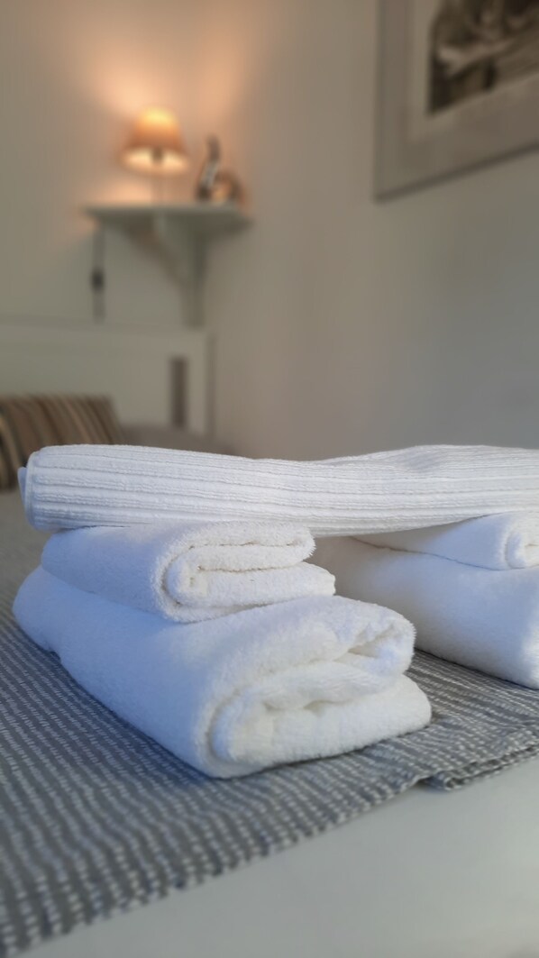 A neatly folded white towel on a textured mat. - Romantic little pirate's house, free WiFi (Monterosso al Mare)